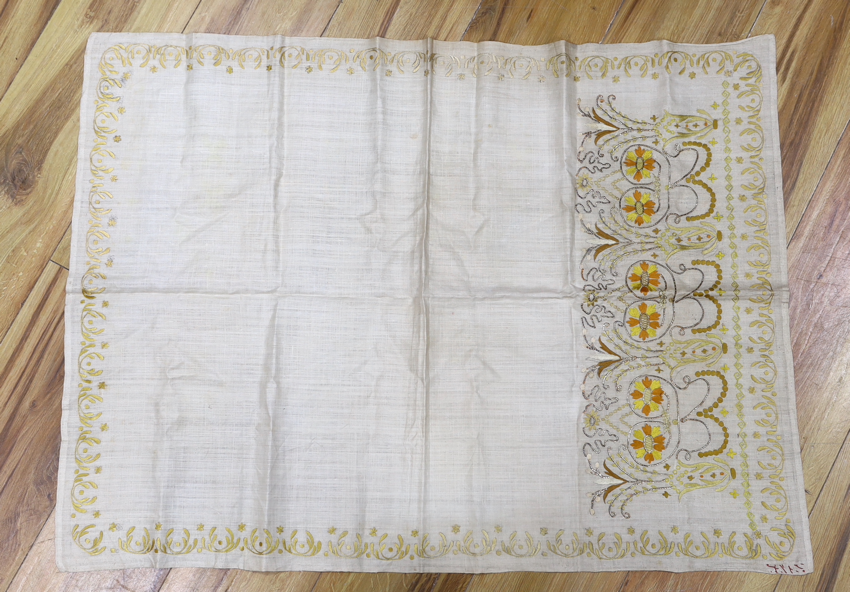 An Indian embroidered panel, a small linen embroidered panel possibly Turkish, a maroon silk length of fabric, heavily embroidered with all over flower motifs, possibly cut from a sari, together with a handwoven linen em